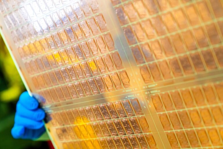 A close-up of the Glass Core Substrate prototype, featuring co-packaged optics and a unique glass-core substrate design, showcasing the future of UK chip technology and innovation in the tech industry