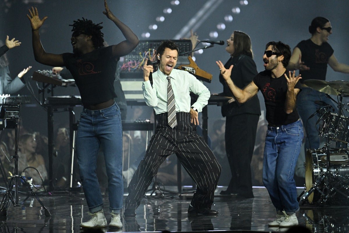 Harry Styles performing on stage with a crowd of fans in the background, with a focus on the stage design and lighting, highlighting the primary keyword phrase 'Harry Styles tour'