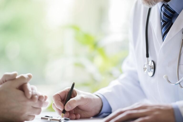 A person holding a sick note, with a blurred background of a doctor's surgery, highlighting the primary keyword 'sick notes' and the UK government's plans to reduce benefit claimants