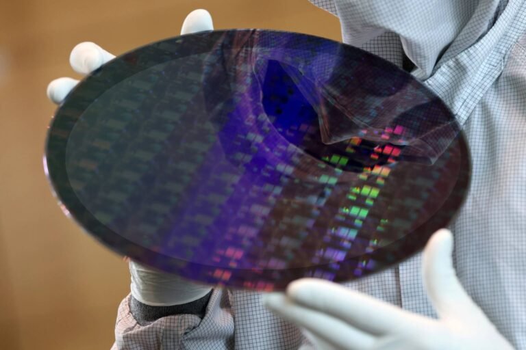 TSMC factory in the UK, with employees working together to produce high-tech components, highlighting the company's commitment to its workforce and the UK's tech industry