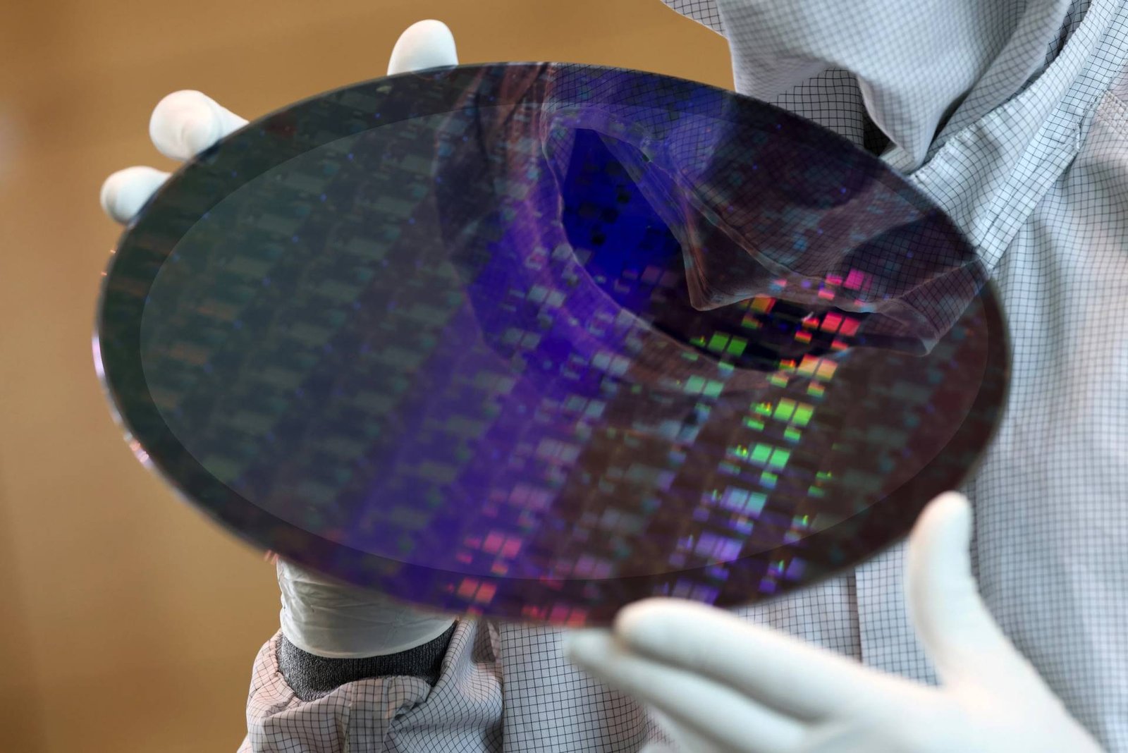 TSMC factory in the UK, with employees working together to produce high-tech components, highlighting the company's commitment to its workforce and the UK's tech industry