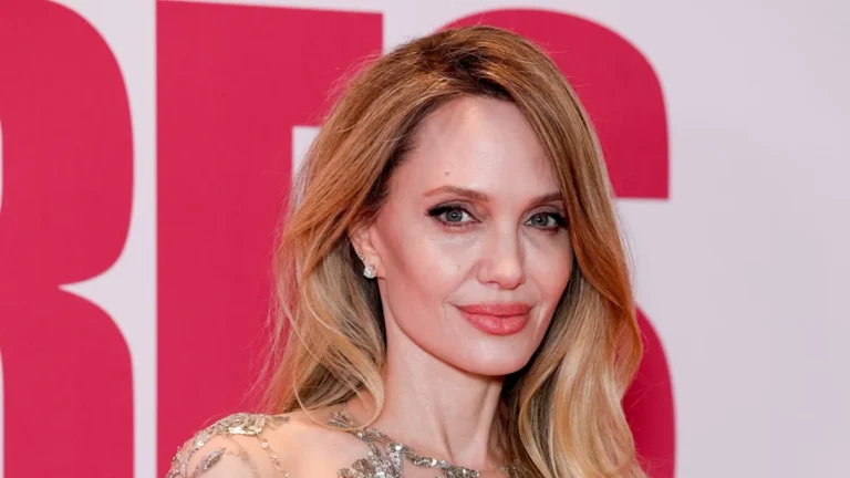 Angelina Jolie wearing a daring 'naked' dress on the red carpet, posing for photographs with confidence and poise, showcasing her latest fashion statement and cementing her status as a style icon