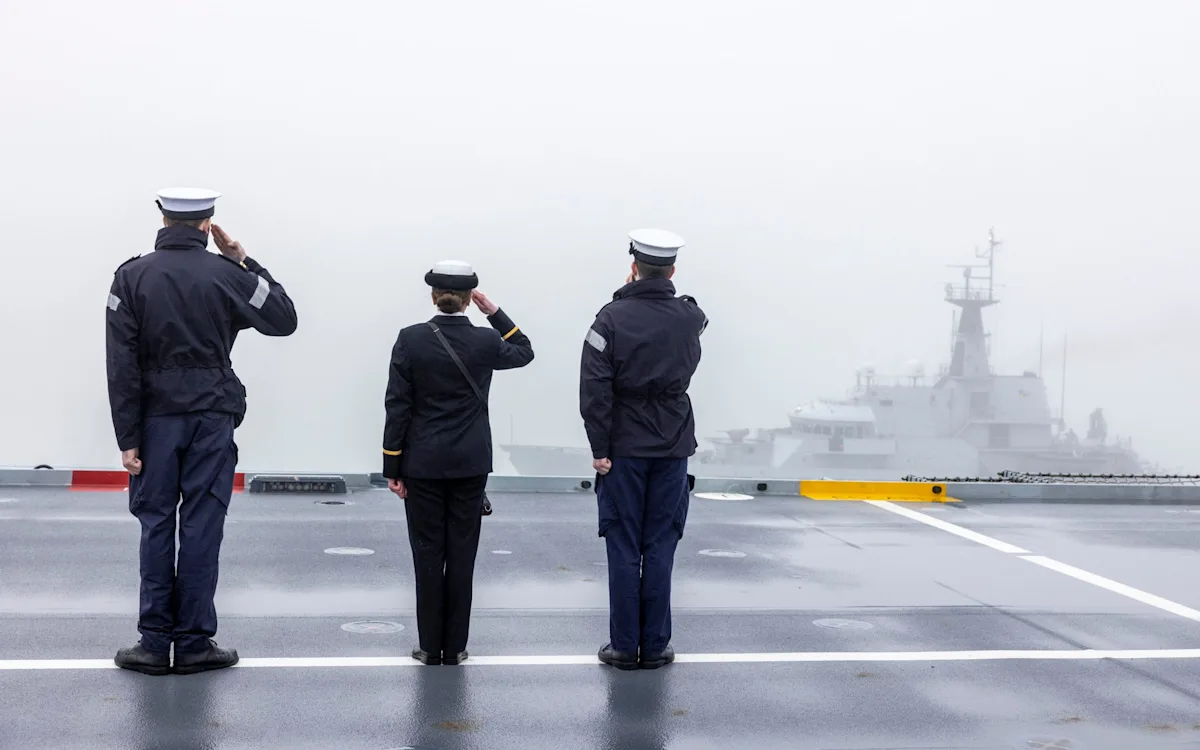A dramatic photo of a NATO base, with military personnel and equipment in the foreground, set against a backdrop of a tumultuous sky, symbolising the uncertainty and change in global defence, with the primary keyword NATO bases featured prominently