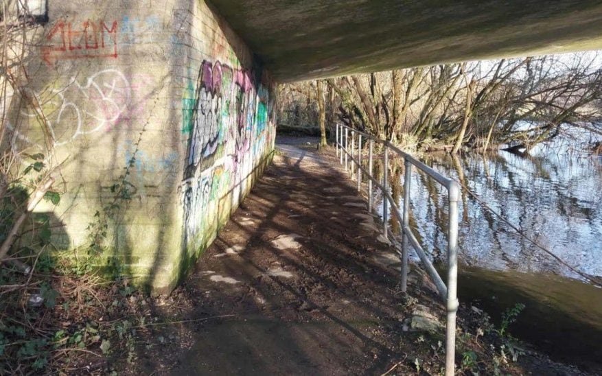 A person holding a sign that reads 'Justice for Rape Victims' at a protest, with a blurred background of people marching and holding similar signs, highlighting the need for a fair and unbiased justice system for victims of rape and the importance of supporting those affected by such crimes