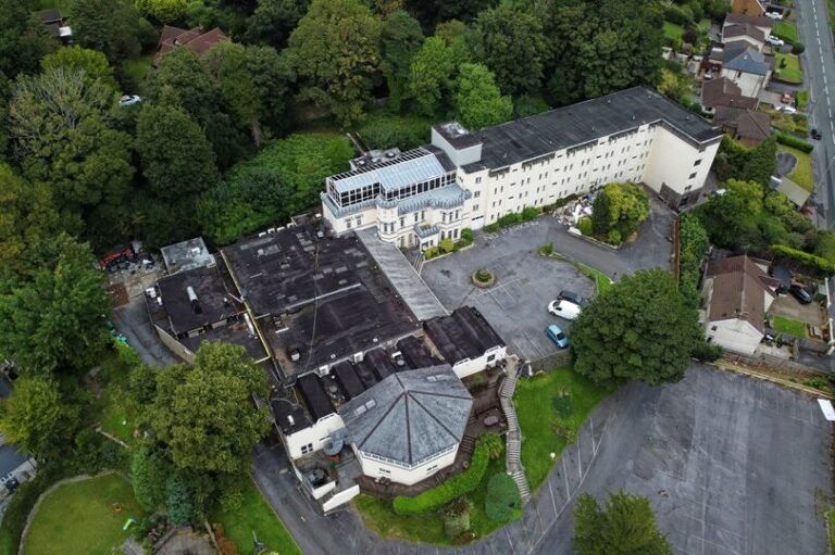 A descriptive image of the abandoned Welsh hotel, showcasing its empty premises and the police warning signs, highlighting the controversy and concern surrounding the hotel's closure, with a focus on the abandoned hotel and its impact on the local community