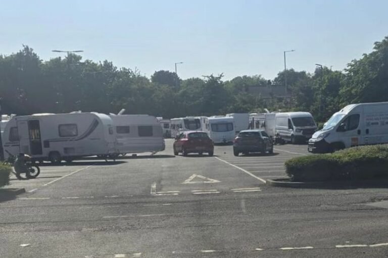 Travellers have set up camp on a car park near B&Q and IKEA in Wednesbury, with makeshift tents and awnings visible. The site has become a hotspot for traveller activity, with local authorities working to address the issue. The car park is located near the junction of two major roads, and the presence of the travellers has caused disruption to the local community. The image shows the car park, with the B&Q and IKEA stores visible in the background.