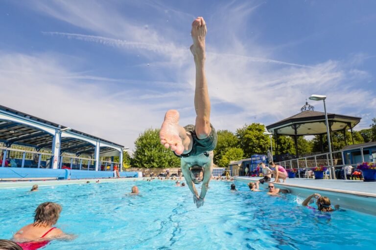A person swimming in cold water, with a shocked expression, highlighting the dangers of cold water shock during heatwaves