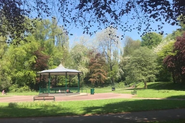 A photo of Willenhall park, where a pensioner was subjected to a racially aggravated attack, with a mix of people from different ethnic backgrounds walking in the park, promoting community cohesion and unity, with a focus on preventing hate crimes