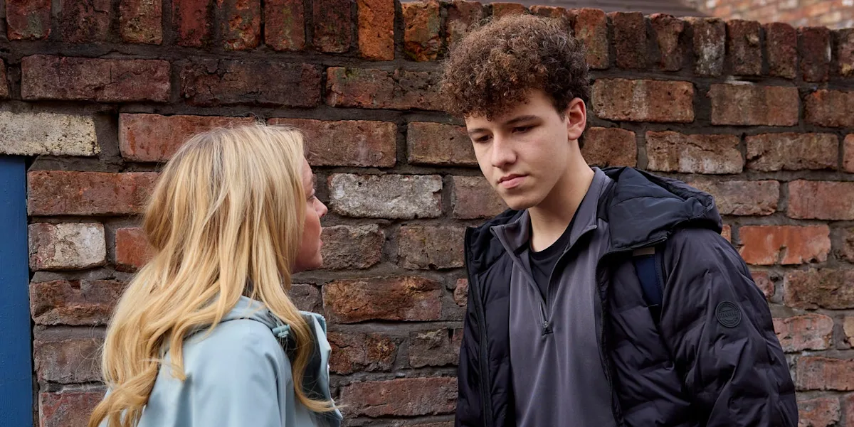 A dramatic scene from Coronation Street featuring Will and Megan, with a dark and ominous colour palette reflecting the mood of the characters, as they engage in a intense confrontation