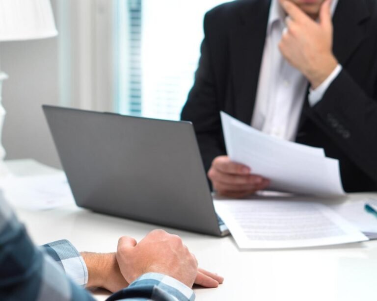 A photo of a recruiter at a desk with a concerned expression, with a cityscape in the background, highlighting the challenges faced by the recruitment industry, including insolvency and financial struggles