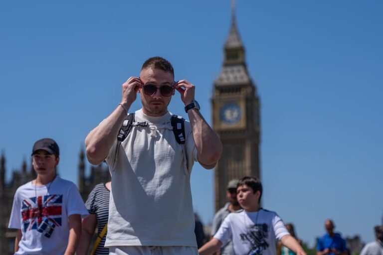 A sunny day in London with people enjoying the warm weather in a park, with a temperature gauge in the corner showing a high reading, heatwave forecast