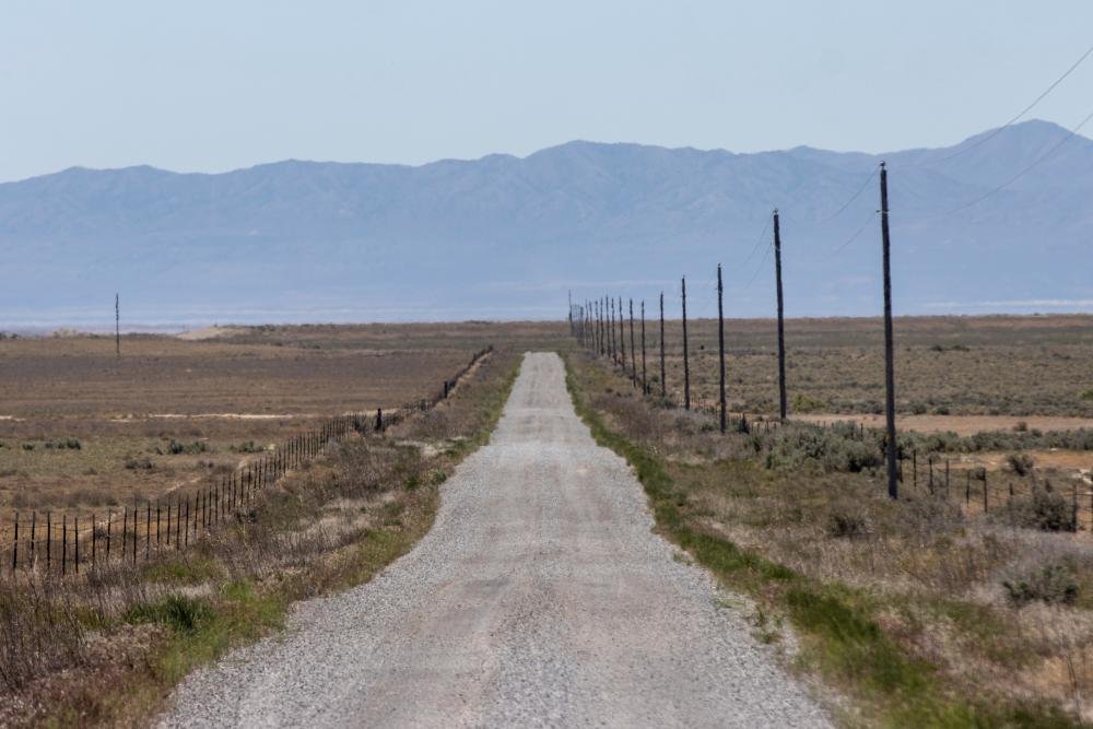 Aerial view of the planned Stratos data centre in Utah, with a backdrop of concerned locals and environmental activists, highlighting the need for responsible and sustainable development, with a focus on the data centre's potential impact on the environment and local communities