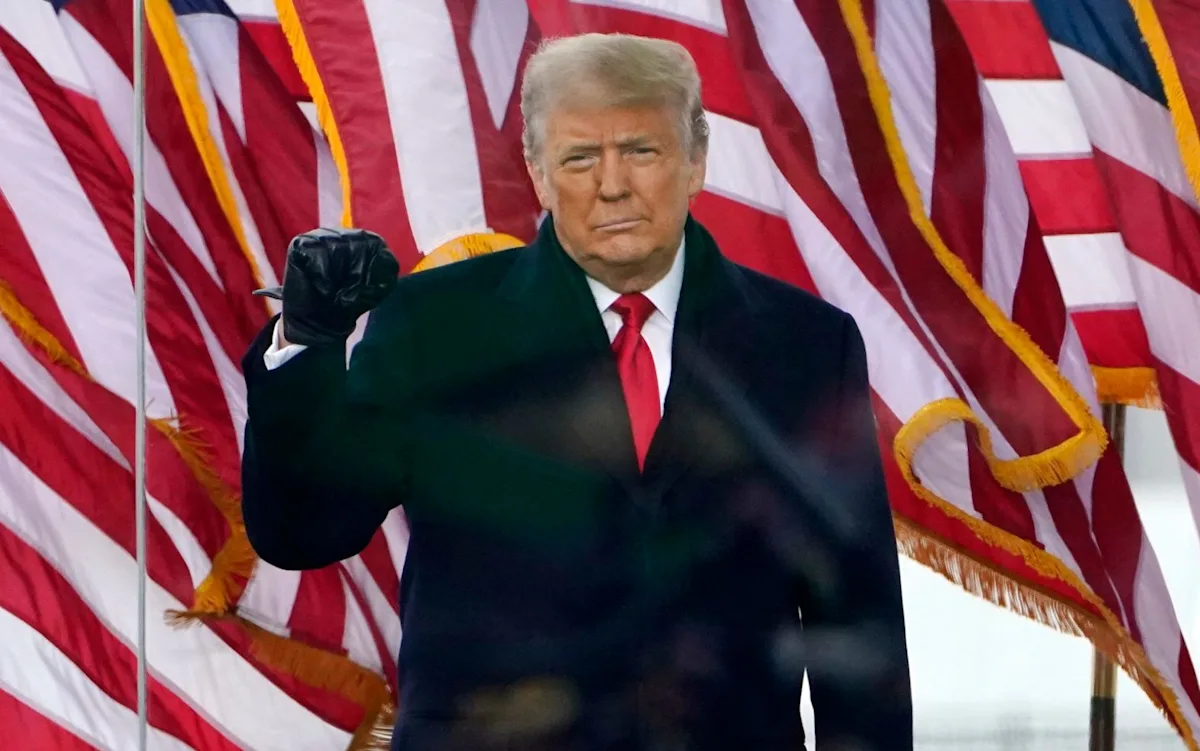 Donald Trump speaking at a press conference, with a BBC logo in the background, symbolising the highly publicised lawsuit between the two, which raises important questions about the limits of free speech and the role of the media in scrutinising those in power