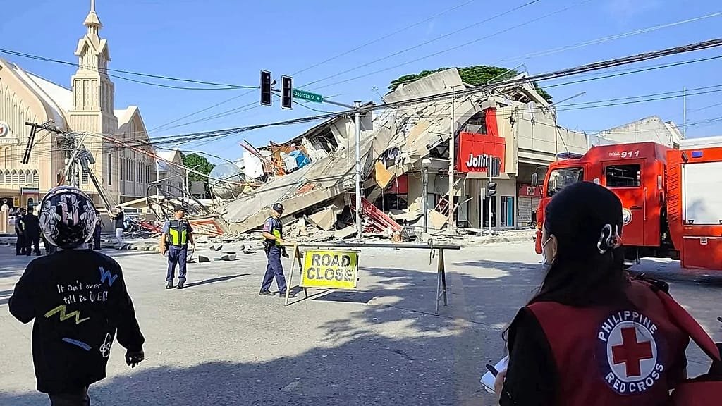 Aerial view of the Philippines with a red tsunami warning symbol overlaid, representing the 7.8 magnitude earthquake that struck the country, triggering widespread tsunami warnings and concerns about seismic activity and disaster preparedness