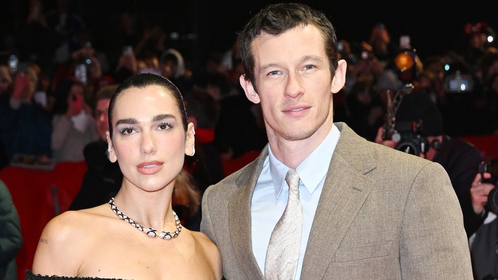 Dua Lipa and Callum Turner exchanging vows in a romantic Sicilian ceremony, surrounded by stunning landscapes and beautiful colour schemes, a perfect example of a celebrity wedding in Sicily