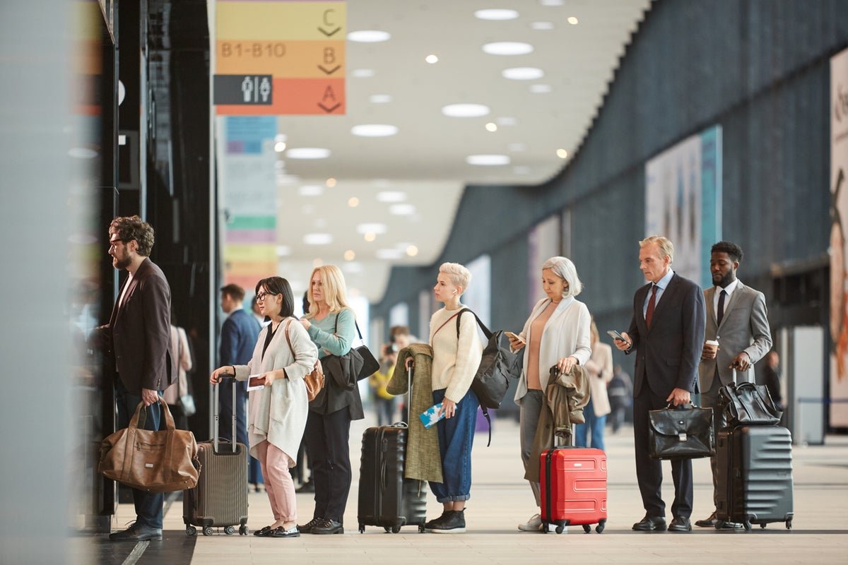 A crowded airport terminal with passengers waiting in line, with a sign reading EU entry-exit checks in the background, highlighting the primary keyword of airport queues and travel delays