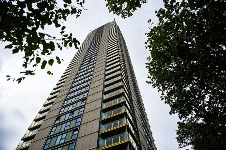Aerial view of a London tower block with a blurred image of a family in the foreground, highlighting the primary keyword phrase 'London tower block tragedy' in a sensitive and respectful manner