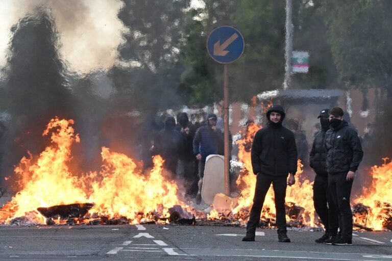 A descriptive image of a protest in Belfast, with a primary keyword of far-right extremism, and a colour palette of black and white, conveying a sense of urgency and importance, as the city struggles to cope with the aftermath of violent protests