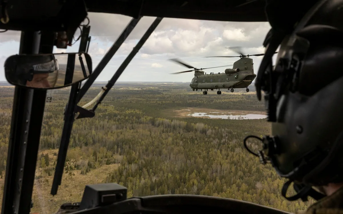 A group of soldiers from the UK brigade participating in a Nato wargame, with a Ukrainian team in the background, highlighting the importance of international cooperation and military training in a simulated environment, with a focus on Nato wargame