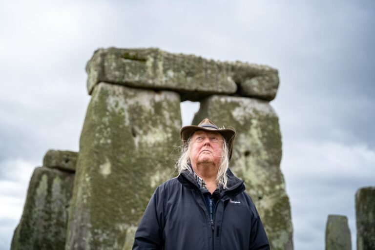 Aerial view of Stonehenge, with its mysterious stones and intricate carvings, set against a backdrop of rolling hills and lush green countryside, embodying the spirit of prehistoric religion in Britain