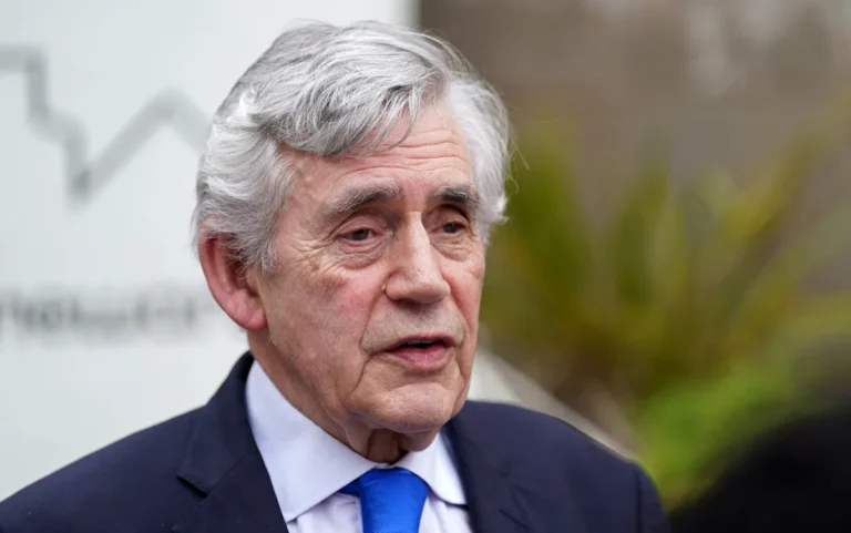 Gordon Brown hands over a dossier on sex trafficking to the police, with a determined look on his face, as he strives to make a difference in the fight against this crime, with a focus on UK authorities and human rights